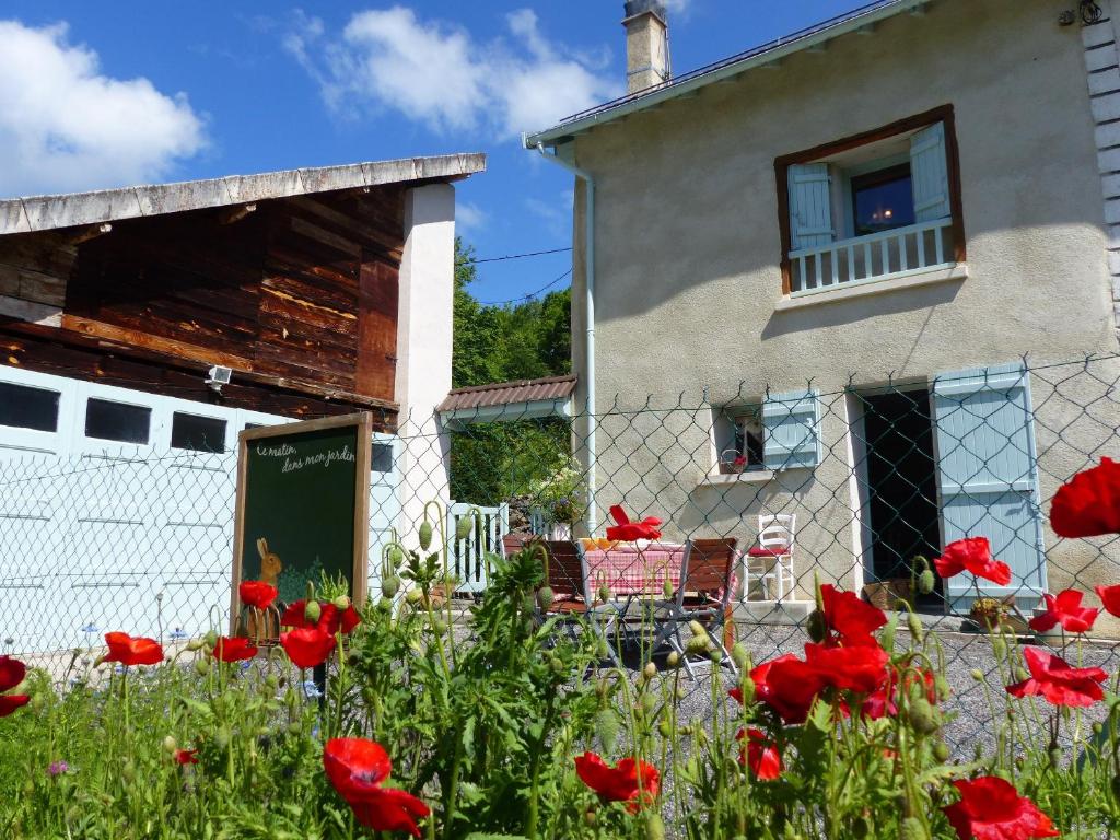 uma casa com flores vermelhas em frente em Gite d'Appy em Les Cabannes
