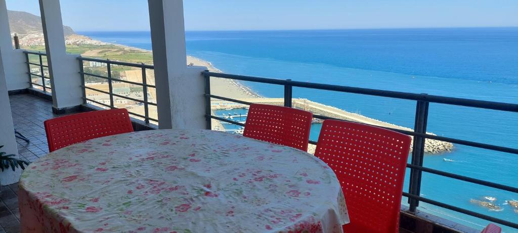 una mesa y sillas con vistas al océano en Dar ElBiad large family house en Ifargane