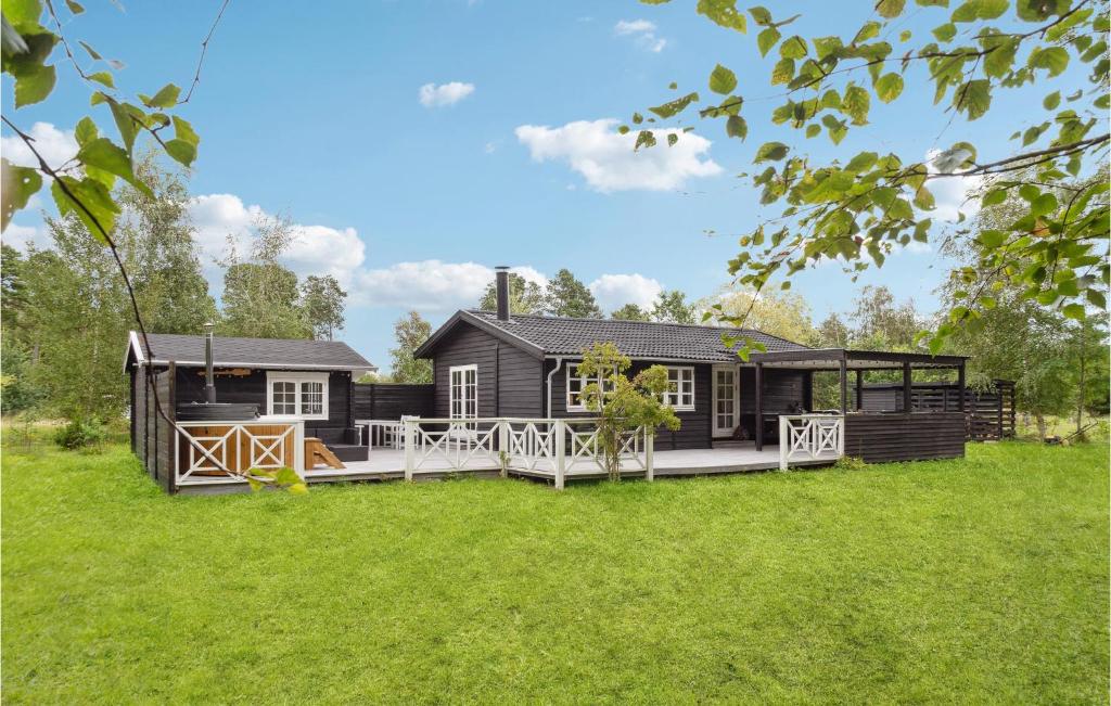 a house with a large deck in the grass at Amazing Home In Rdby With Wifi in Rødby
