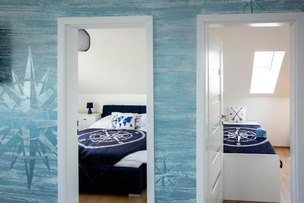 Schlafzimmer mit blauen Wänden, einem Bett und einem Spiegel in der Unterkunft Ahoy Relax Apartmán Ocean in Nesvady