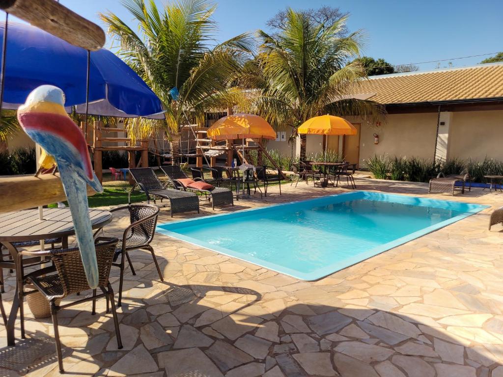 a pool with a bird statue next to a table and chairs at Hotel Pousada Parque das Águas in Olímpia