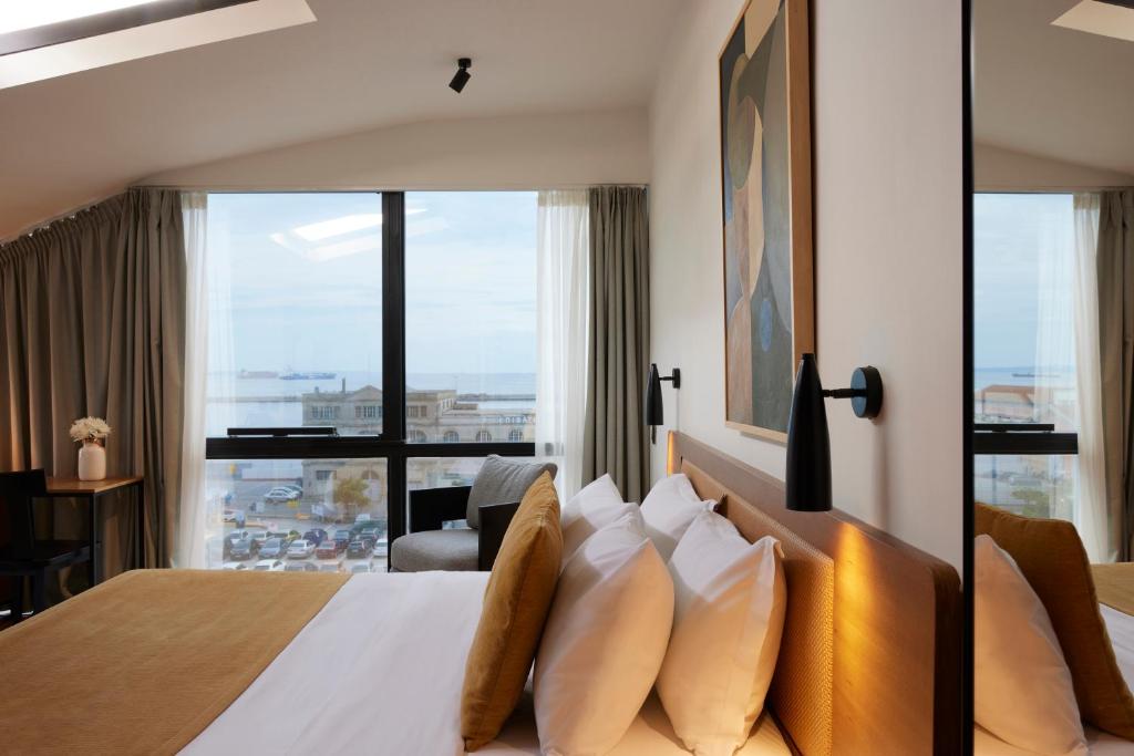 a hotel room with a bed with a large window at Noa Hotel in Thessaloniki