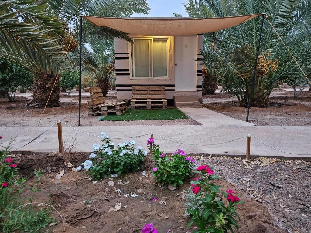 a house with a gazebo and flowers in front of it at Almazham hotel room resort in AlUla