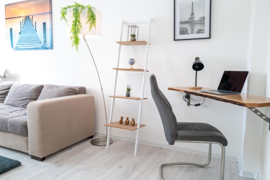 a living room with a couch and a desk and a chair at #411 Comfort-Wohnung in Mülheim in Mülheim an der Ruhr