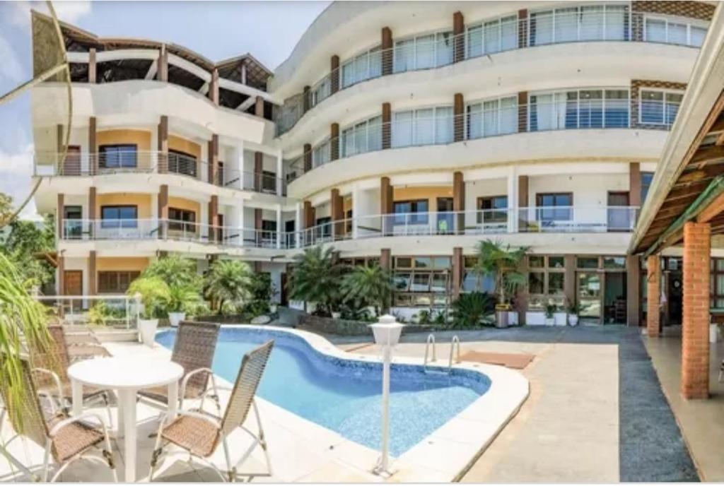 um edifício de apartamentos com uma piscina e um resort em Hospedaria Vitória Mar em Ubatuba