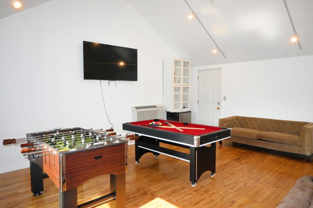 a living room with a foosball table and a couch at Modern Home in New Haven in Hamden