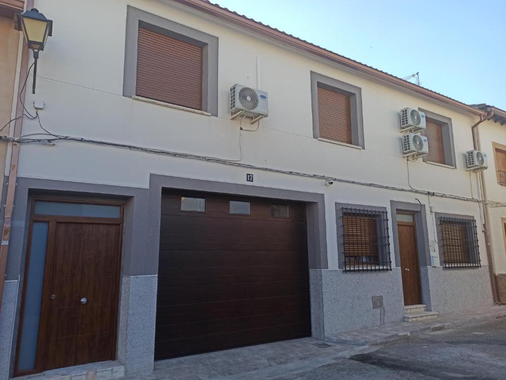 un edificio blanco con dos puertas y ventanas de garaje en Conde Lucanor, en Belmonte