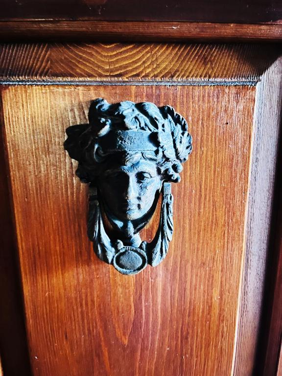 a door with a bust of a woman on it at Historic Alex Castle Apartment Lake Como in Gravedona