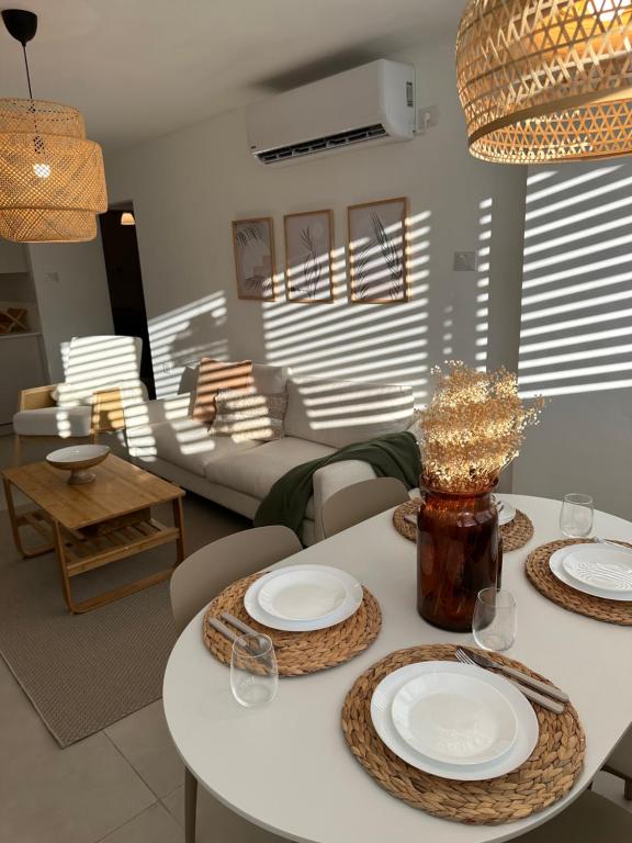 uma sala de estar com uma mesa branca e cadeiras em BOHO and BE em Qiryat Shemona
