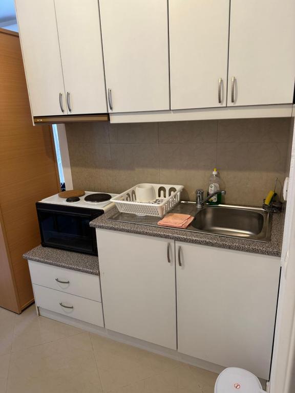 a kitchen with white cabinets and a sink at Ksamildream in Ksamil