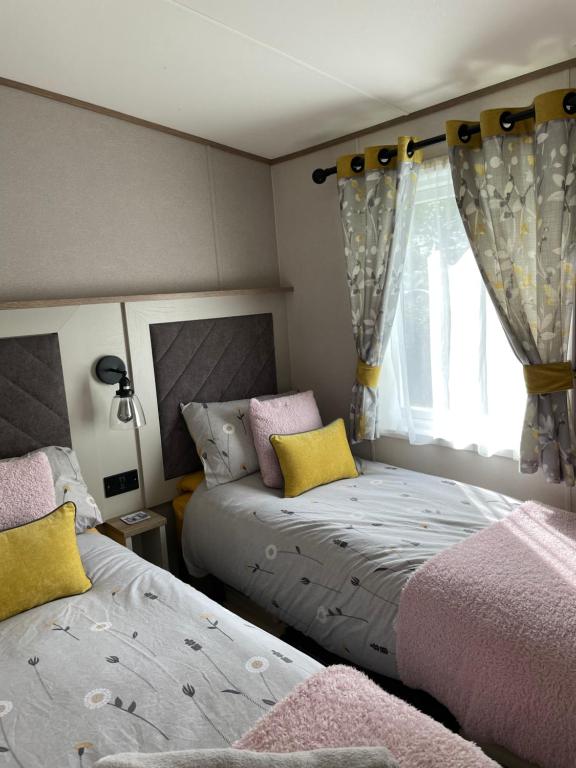 a bedroom with two beds and a window at Ellis Retreats at Tattershall Lakes in Lincoln