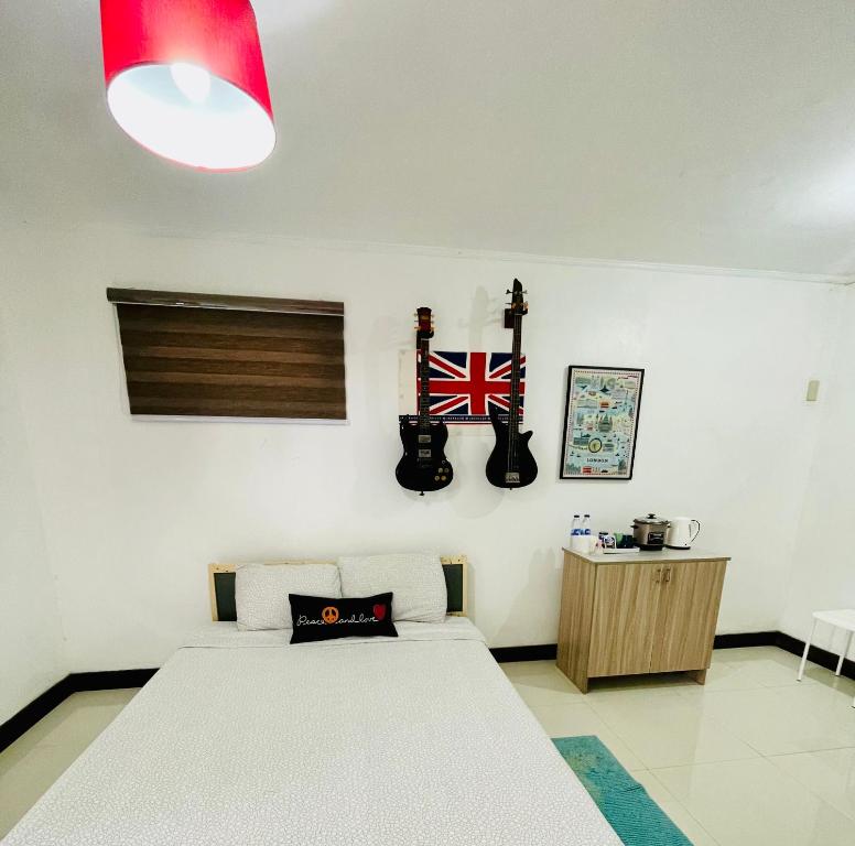 a bedroom with a bed and guitars on the wall at London Unit Tagaytay Wifi/Netflix/Parking in Tagaytay