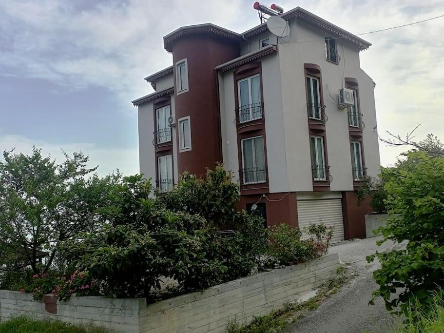 a large red and white building with bushes in front of it at SEA WİEW AND MOUNT WİEW 6 BEDROOMS,4 BATHROMS in Trabzon