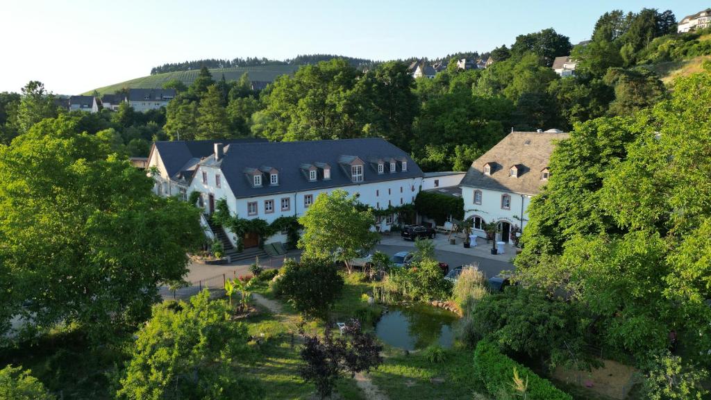 an aerial view of a large white building with a courtyard at Hotel und Weingut Karlsmühle in Mertesdorf