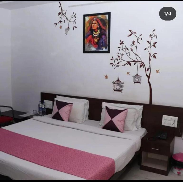 a bedroom with a bed and a painting on the wall at HOTEL kalika palace in Udaipur