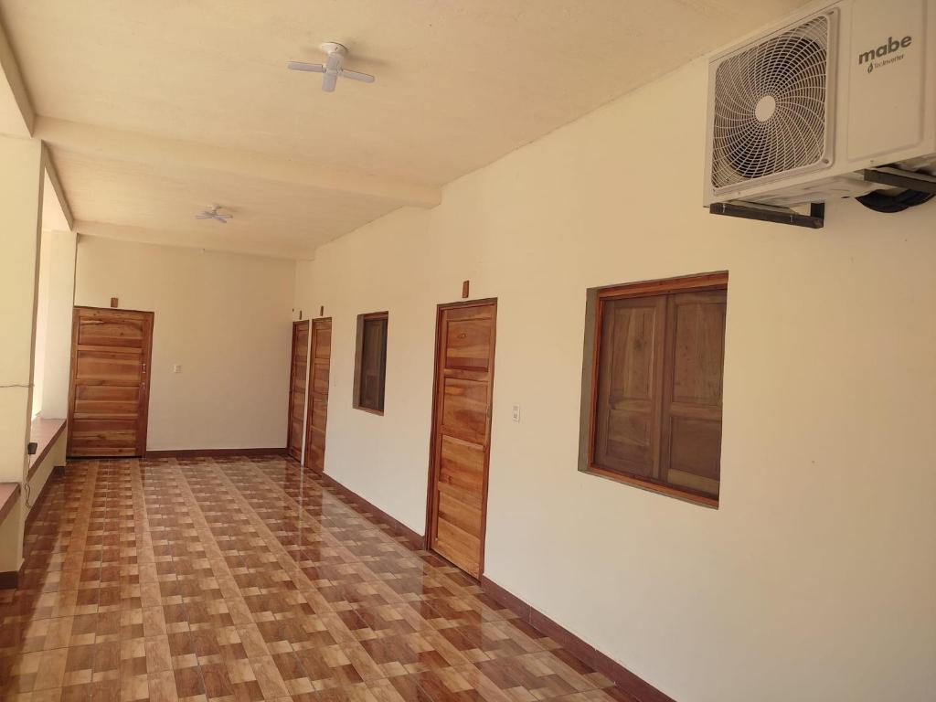 Habitación vacía con paredes blancas y suelo de madera. en Hostal las 3 J en Suchitoto