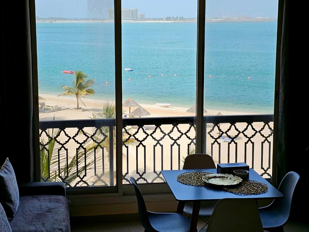 a room with a view of the beach from a balcony at Dream studio panoramic beach and sea view in Ras al Khaimah