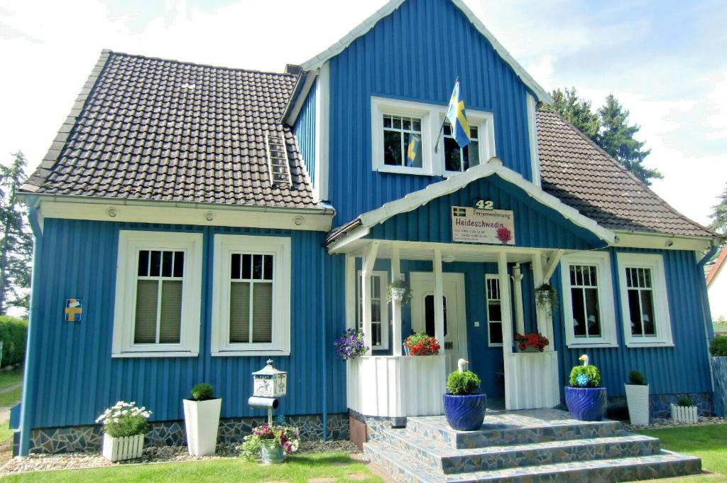 uma casa azul com um branco em Ferienwohnung Heideschwedin l em Eschede