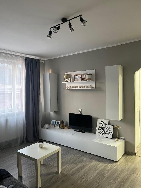 a living room with a white couch and a table at CENTRAL VIEW APARTAMENT in Arad