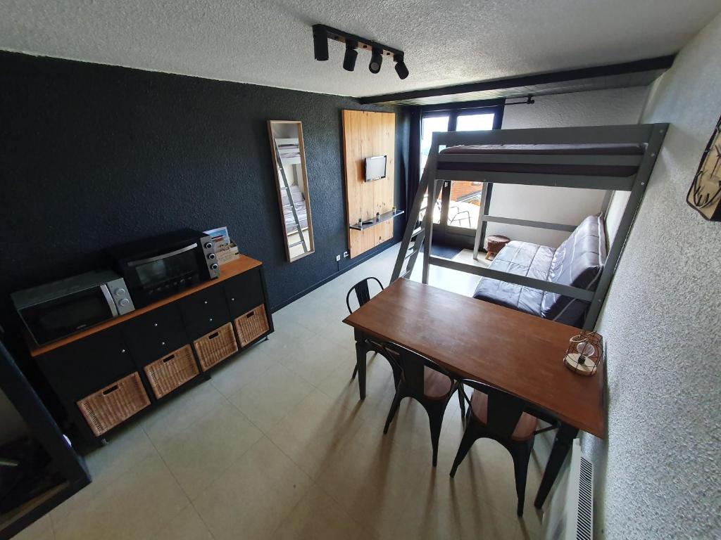 Cette chambre comprend une table et des lits superposés. dans l'établissement Les saisies-gîte les carolos, aux Saisies