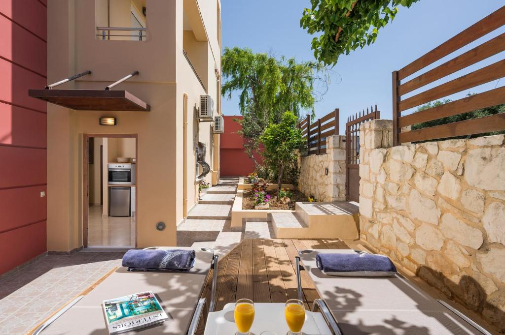 un patio avec une table et des chaises et un bâtiment dans l'établissement Anna Boutique Apartment, à Kato Daratso