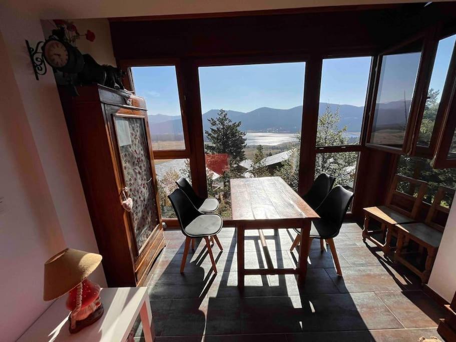 a room with a table and chairs and a large window at Chalet Triplex aux Angles vue sur le lac et au pied des pistes in Les Angles