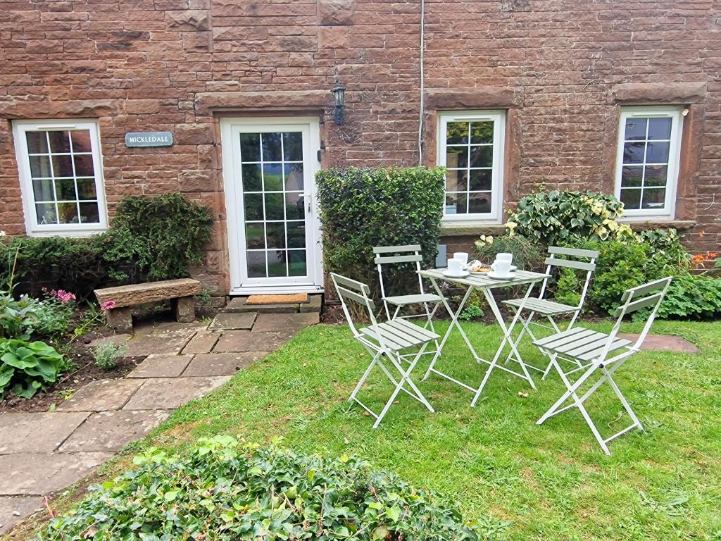 a patio with a table and chairs in a yard at Mickledale at Wetheral Cottages in Great Salkeld