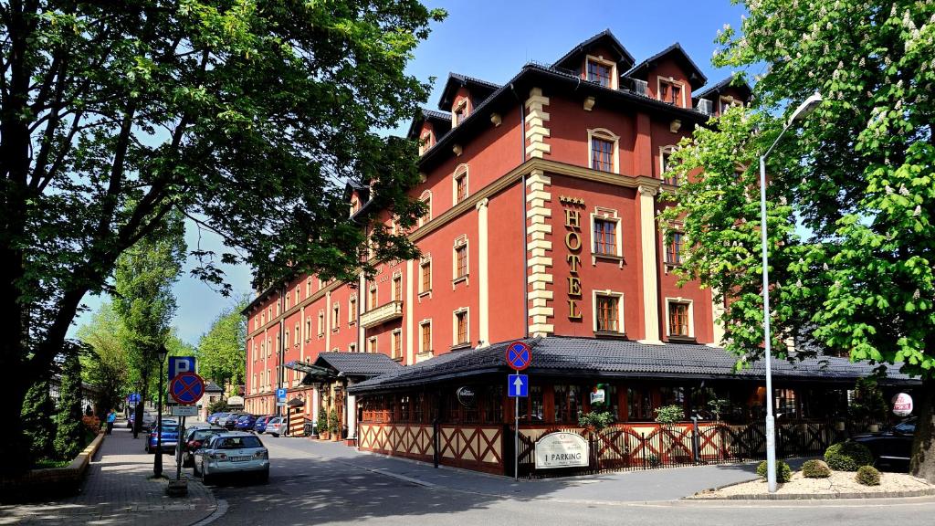 a large red brick building on a city street at Hotel Diament Arsenal Palace Katowice - Chorzów in Chorzów