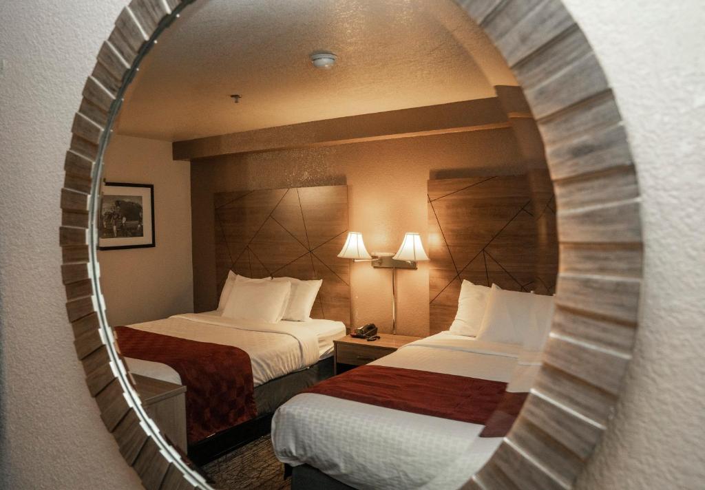 Habitación de hotel con 2 camas y espejo en Americas Best Value Inn Lynnwood, en Lynnwood
