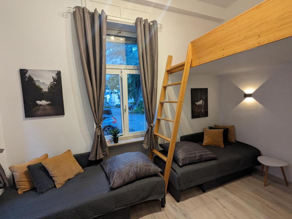ein Schlafzimmer mit einem Etagenbett und einem Sofa in der Unterkunft Schönes Apartment am Rhein - Zentral 1 in Koblenz