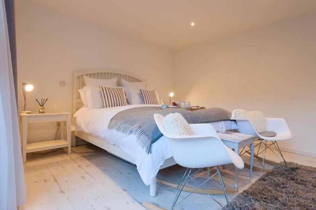 a bedroom with a bed with two chairs and a table at The retreat in West Mersea