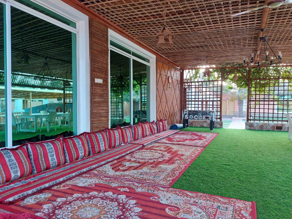 a porch with red leather chairs on a house at AlMazyona Chalet إستراحة المزيونه للتأجير in As Suwayq