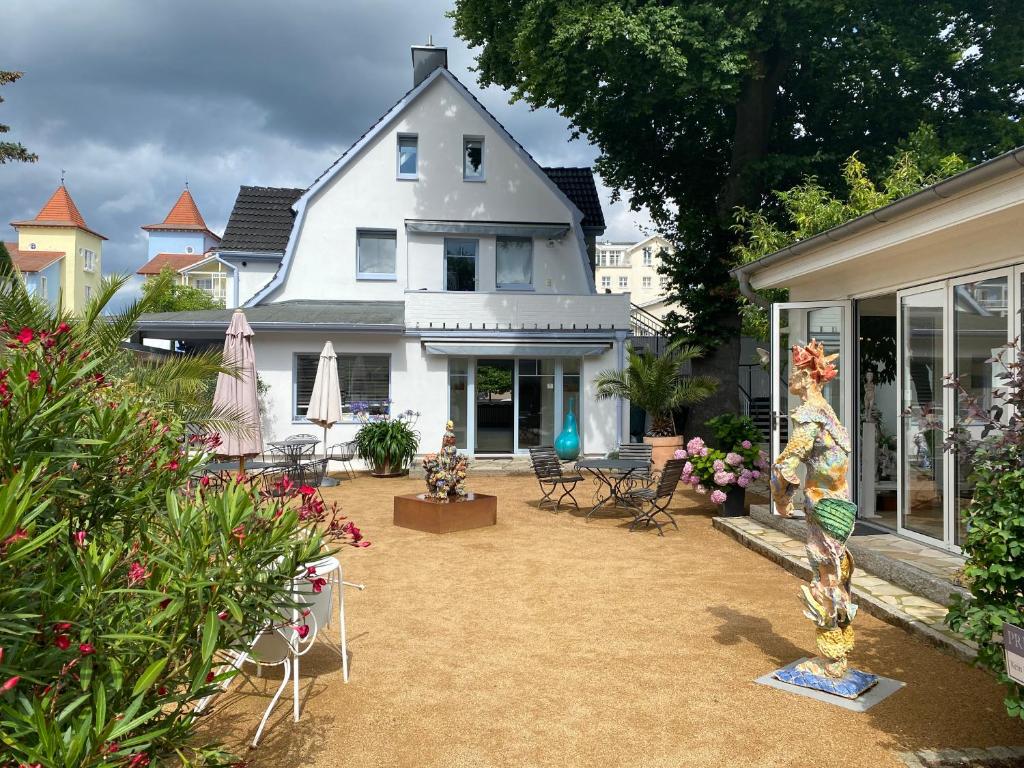 uma casa com um quintal com cadeiras e flores em Usedom Refugium em Zinnowitz