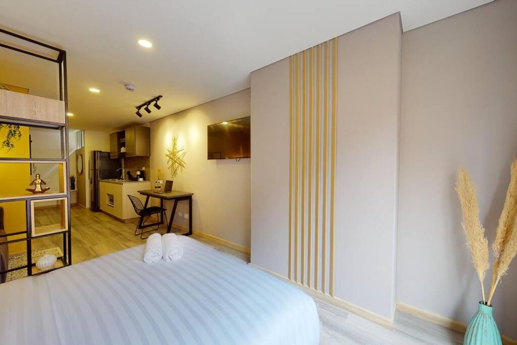 um quarto com uma grande cama branca e uma cozinha em LoftVista Cabrera 85 em Bogotá