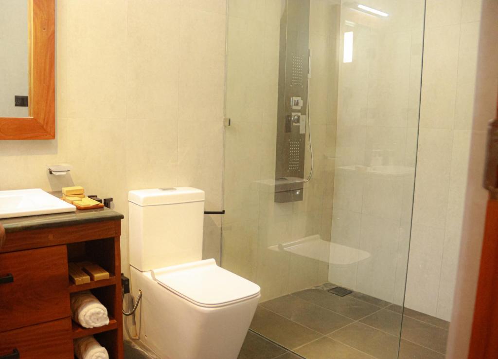 uma casa de banho com um WC e uma cabina de duche em vidro. em Moana La Vie - Polhena em Matara
