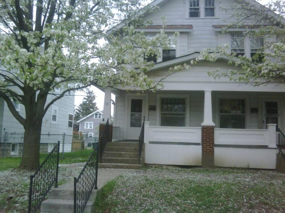 uma casa branca com um portão e uma árvore em Quiet 3 bed with fenced yard em Columbus