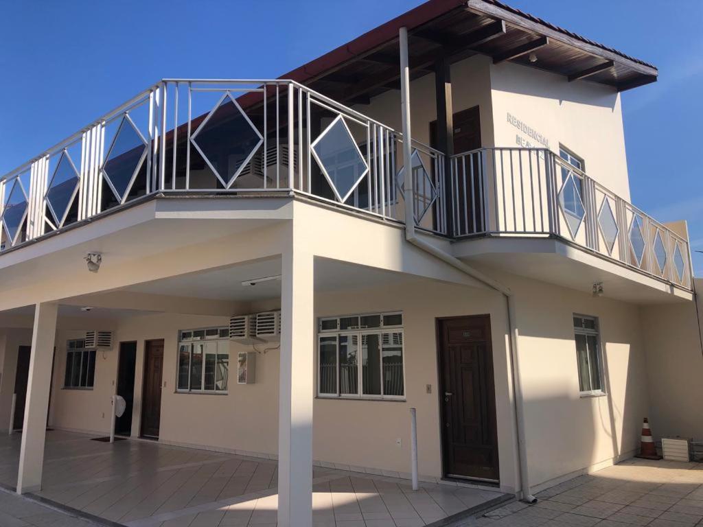 a white building with a balcony on top of it at Residêncial Beatríz in Florianópolis