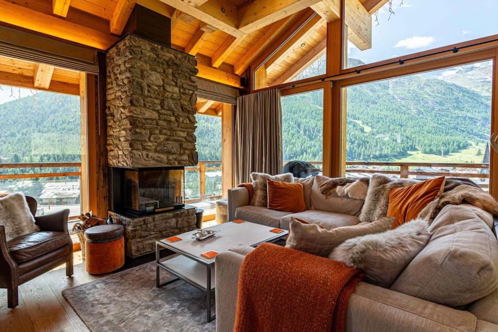 a living room with a couch and a fireplace at Sonnhalde II - Luxury Chalet in Saas-Fee