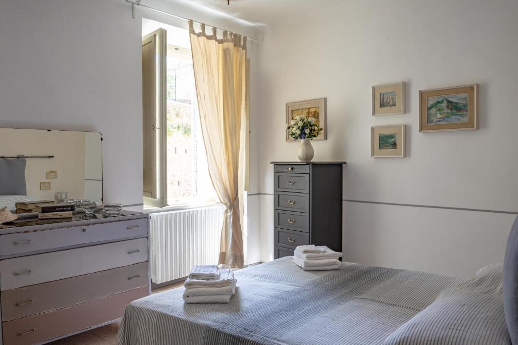 a bedroom with a bed and a dresser and a window at Casa vacanze nel centro storico di Fermo Happy Song in Fermo