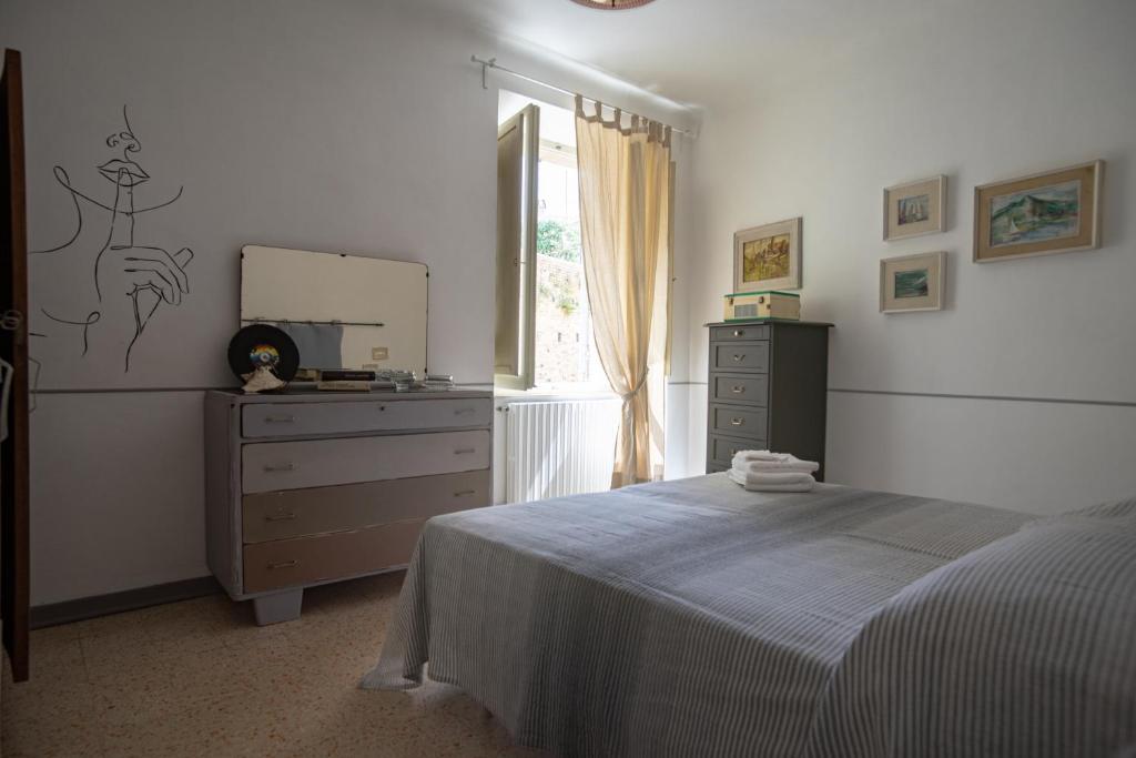 - une chambre avec un lit, une commode et un miroir dans l'établissement Casa vacanze nel centro storico di Fermo Happy Song, à Fermo