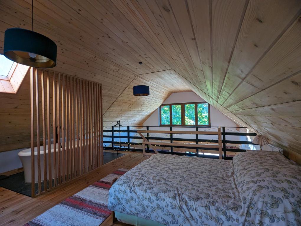1 dormitorio con 1 cama en una habitación con paredes de madera en Makowy domek, en Maków Podhalański