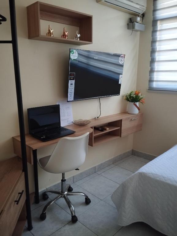 een slaapkamer met een bureau met een laptop en een computermonitor bij Posada del sol in Manta
