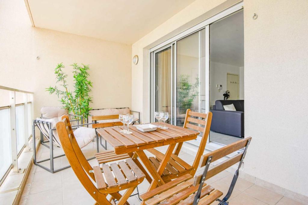 uma sala de jantar com uma mesa de madeira e cadeiras em Appart 1 ch balcon proche Saint-Charles et métro em Marselha