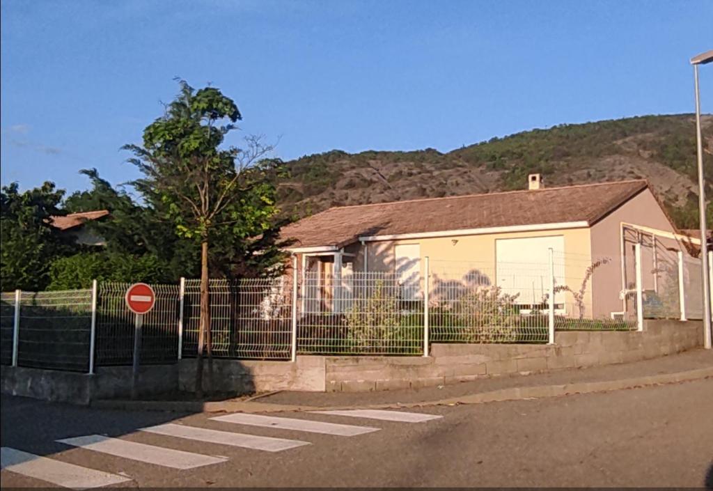 a house with a fence in front of it at Chambre chez l'habitant "Entre Airs et Montagnes" in Tallard
