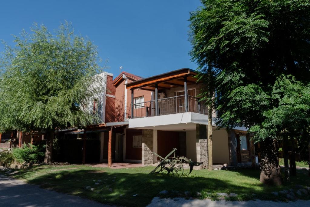 una casa con un árbol delante de ella en Cabañas Ludmar en Potrero de los Funes