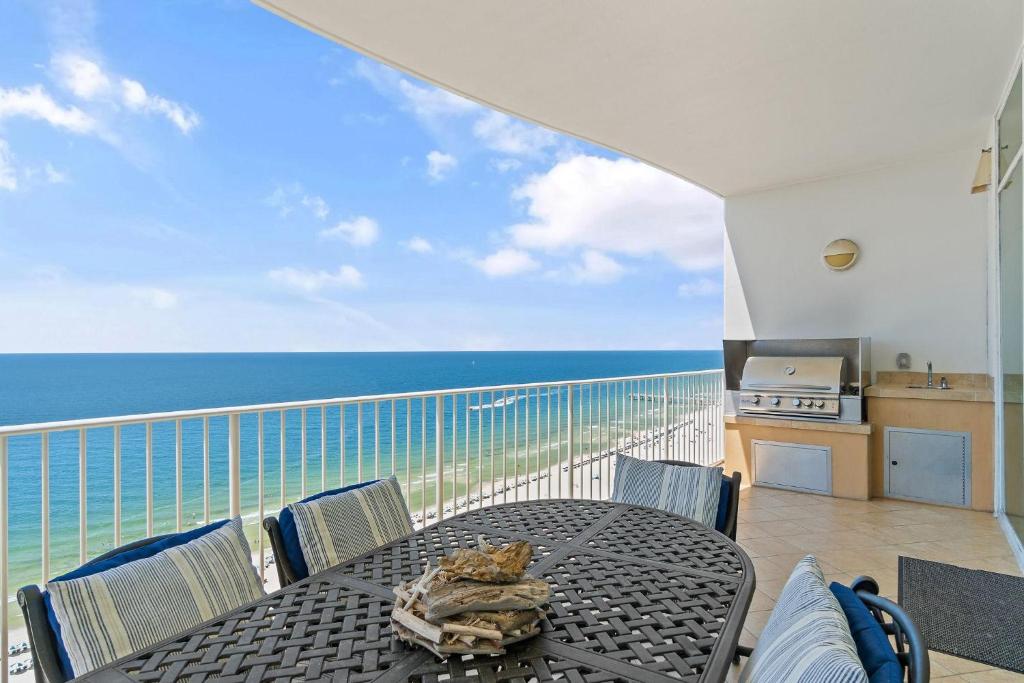 a table and chairs on a balcony with the ocean at Turquoise C1706 in Orange Beach