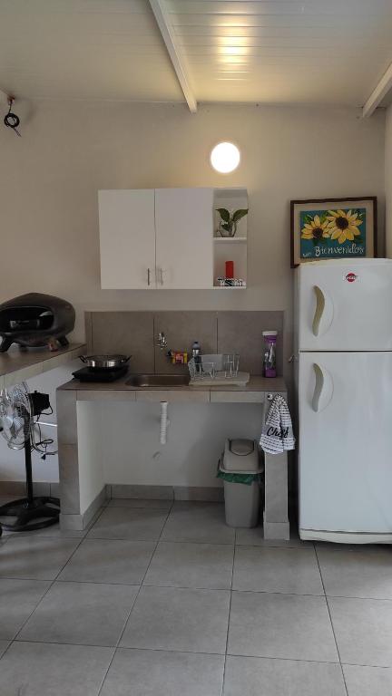 uma cozinha com um frigorífico branco e um lavatório em La Hacienda em Atyrá