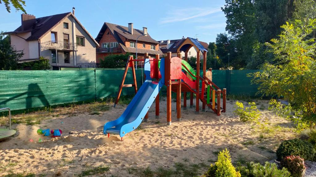 un parque infantil con un tobogán en un patio en Apartament GUNER, en Bełchatów
