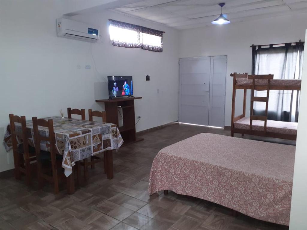 Pokój z 2 łóżkami, stołem i krzesłami w obiekcie Departamentos Rosales w mieście Valeria del Mar