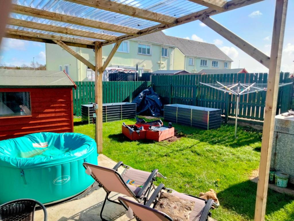 a backyard with a hot tub and a wooden pergola at 19 Doran Close in Donegal